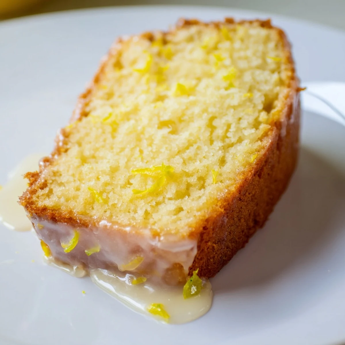 Close-up of freshly baked Lemon Yogurt Cake, showcasing a moist crumb and bright lemon flavor.