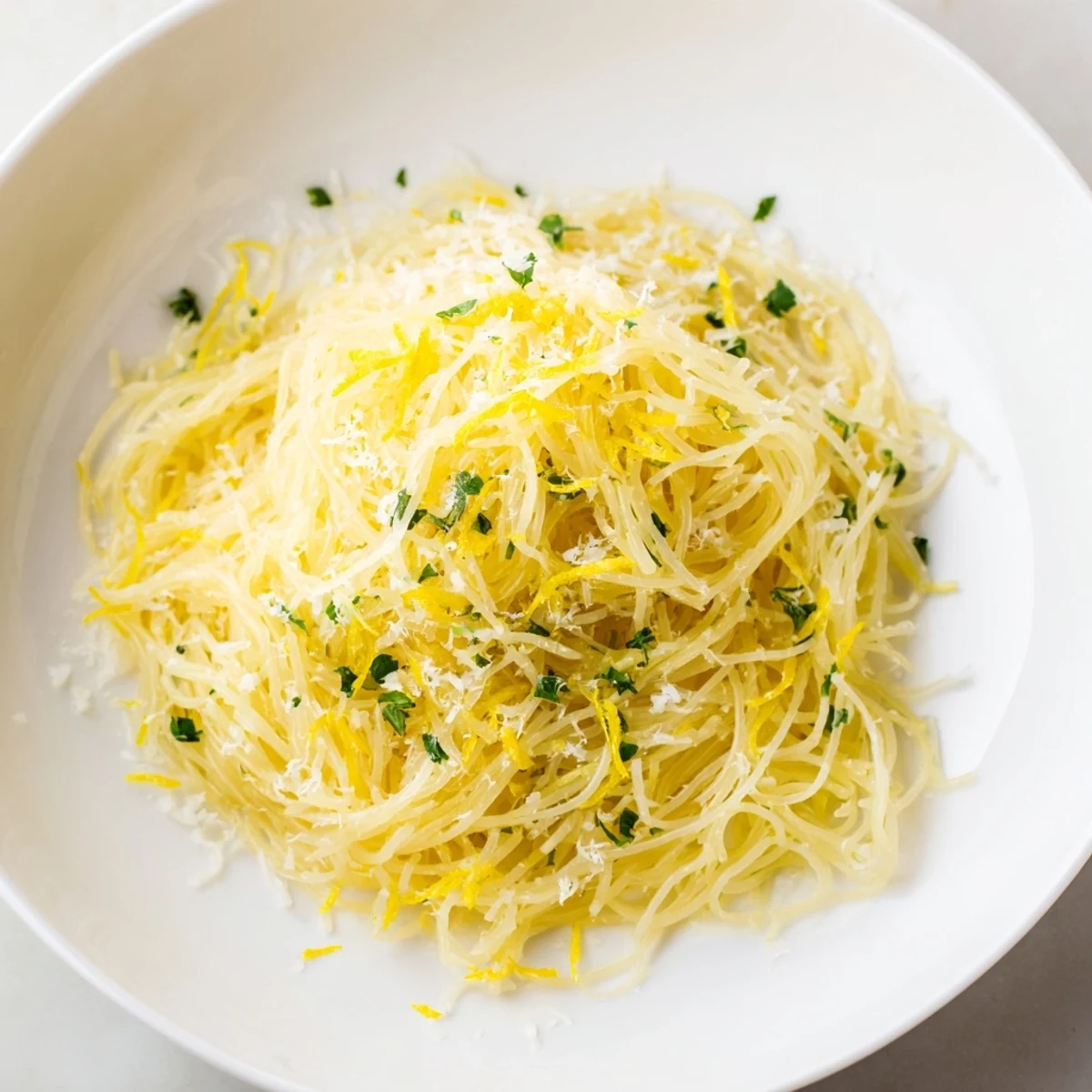 A vibrant bowl of Lemon Capellini, garnished with fresh herbs, ready for a delicious vegetarian meal.