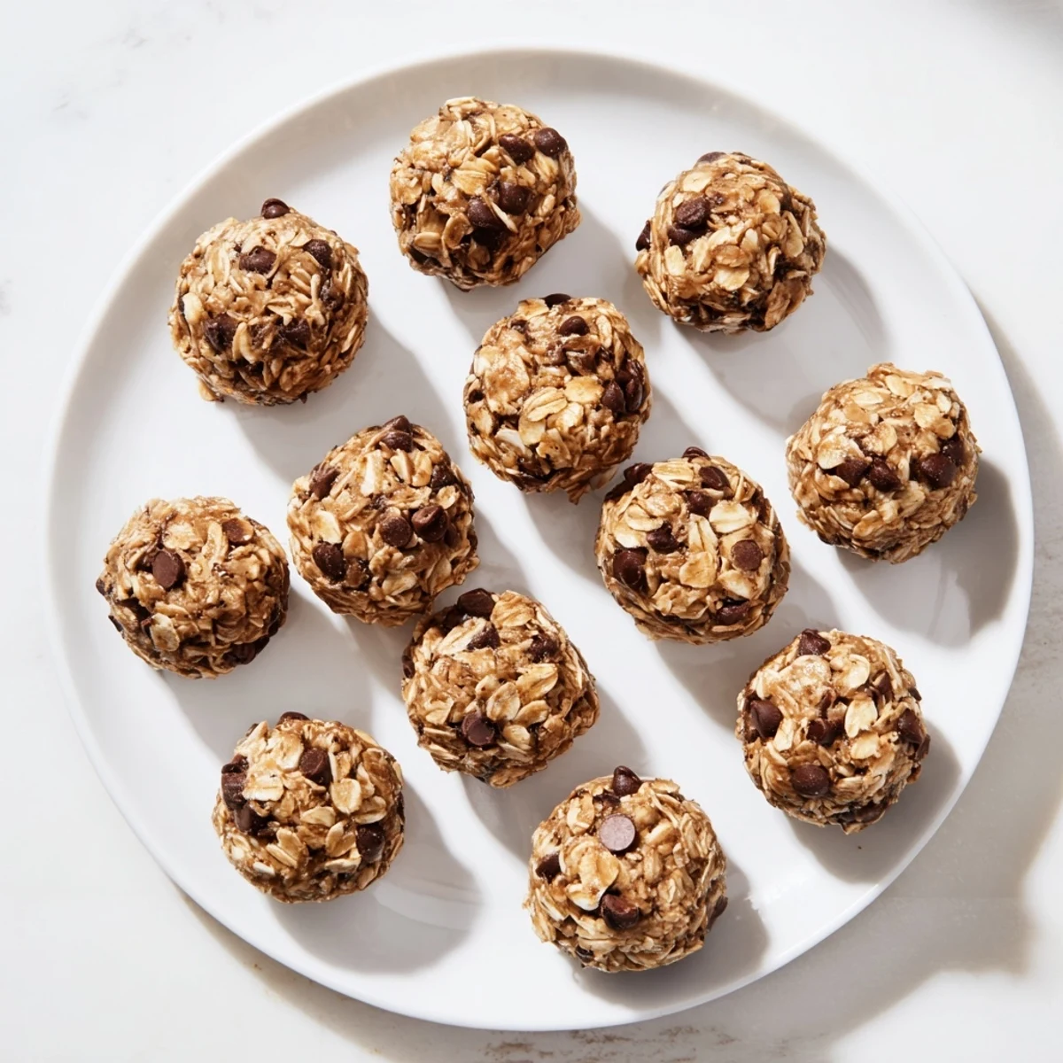 A close-up of Banana Chocolate Chip Energy Balls revealing rolled oats, melted chocolate chips, and a warm nut butter aroma, perfect for a quick healthy snack.