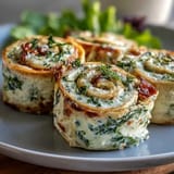 Turkey, Cheese & Spinach Tortilla Pinwheels: Creamy cheese spread and tender turkey rolled with fresh spinach in soft tortillas, sliced into colorful party bites.