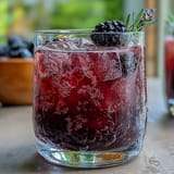 A bubbly glass of homemade blackberry lavender lemonade fizz, perfect for parties.