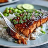 Fluffy rice topped with tender teriyaki-glazed salmon, crisp cucumber, and bright green edamame for a balanced meal.