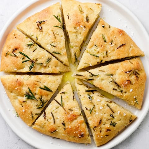 A warm, rustic image of freshly baked Yeast-Free Garlic and Rosemary Bannock Bread, perfect with hearty soups.