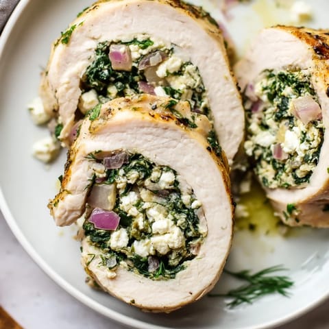 Close-up of baked Spinach Feta Stuffed Chicken, showing a creamy feta and spinach filling.