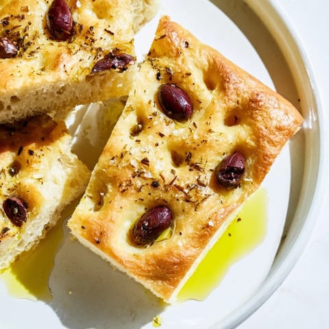 Freshly baked Zaatar Olive Focaccia, with plump olives and a rustic, dimpled texture, ready to eat.