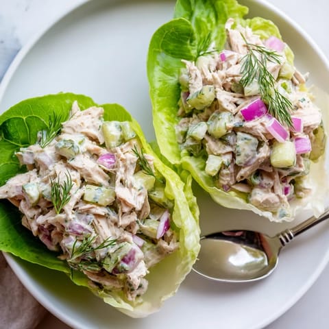 Tangy Dill Pickle Chicken Salad Lettuce Cups filled with a creamy blend of chicken, pickles, red onion, and dill, perfect for a light lunch.