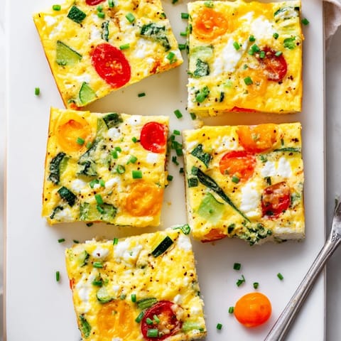 Fluffy High-Protein Sheet Pan Eggs With Cottage Cheese and Veggies fresh from the oven, baked in one pan with colorful diced zucchini and red onion for an easy, protein-packed morning meal.