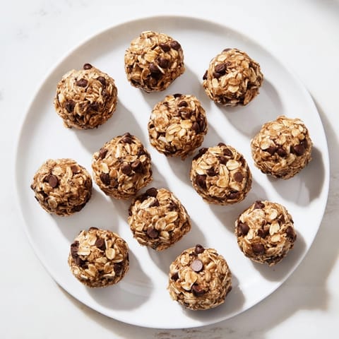 A close-up of Banana Chocolate Chip Energy Balls revealing rolled oats, melted chocolate chips, and a warm nut butter aroma, perfect for a quick healthy snack.