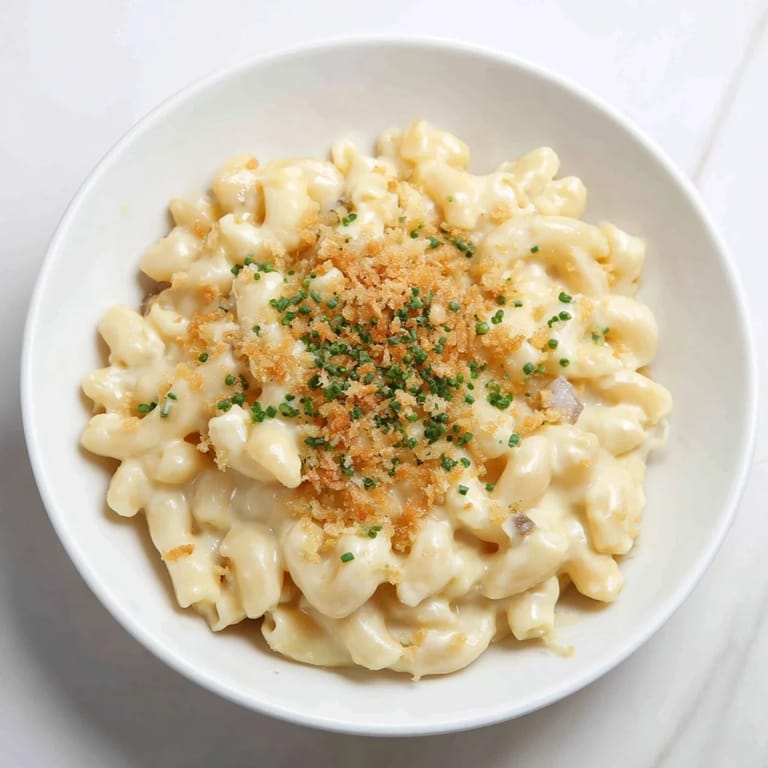 A close-up of creamy Stove-Top Mac and Cheese, garnished with fresh chives, ready to eat.