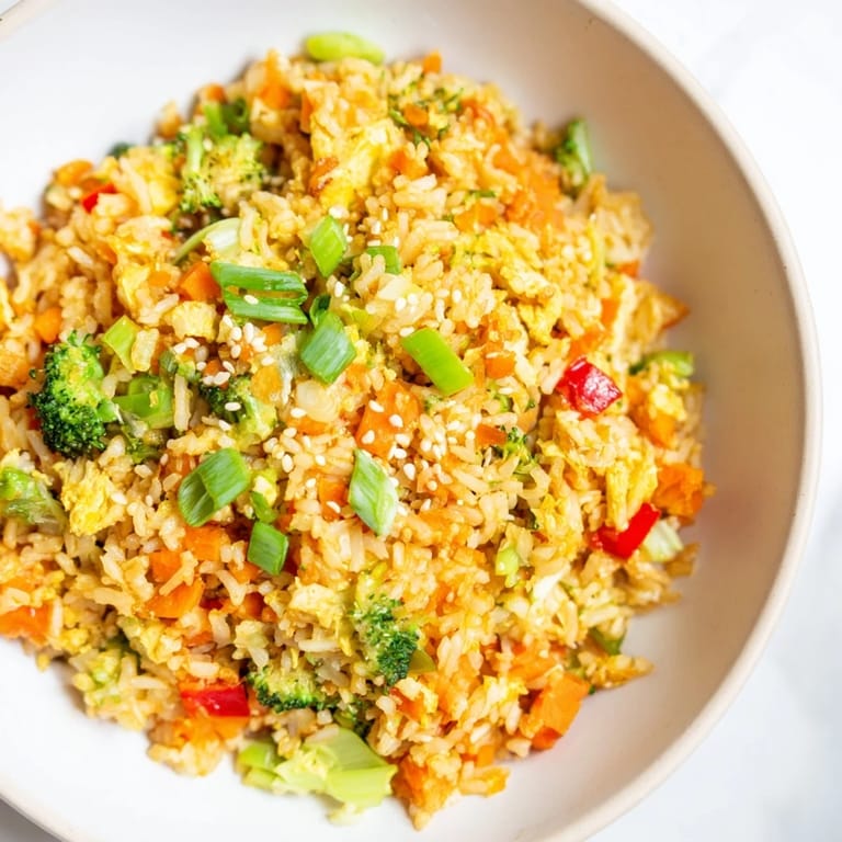 A steaming bowl of vegetable fried rice, showing off perfectly fried rice and fresh cilantro.