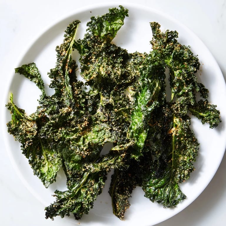 Freshly baked crispy kale chips, appearing wonderfully textured and seasoned for your healthy snack enjoyment.