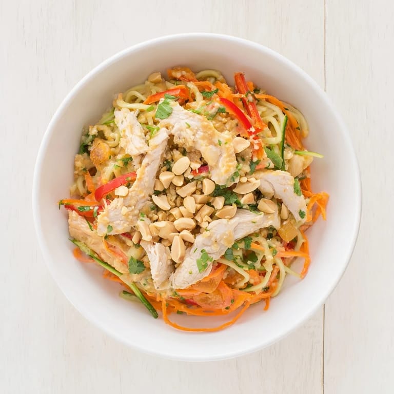 This close-up shot of Thai-Inspired Peanut Chicken Pasta shows a perfect blend of flavors and textures ready to eat.