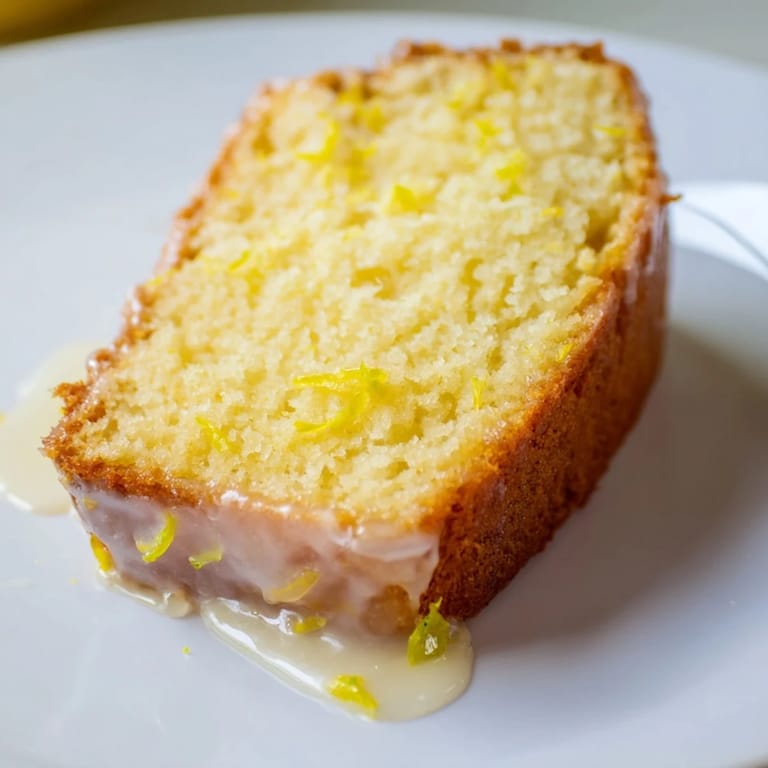 Close-up of freshly baked Lemon Yogurt Cake, showcasing a moist crumb and bright lemon flavor.
