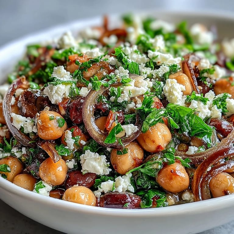 Freshly chopped parsley and thinly sliced red onion garnish the marinated bean salad, ready to serve.