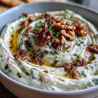 Creamy whipped feta dip with golden honey drizzle, crunchy walnuts, and fresh herbs served with warm pita bread.  